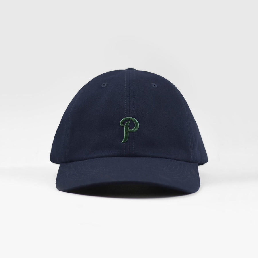 Granatowa czapka z zielonym, wyhaftowanym monogramem. Navy blue baseball cap with green embroidered logo.